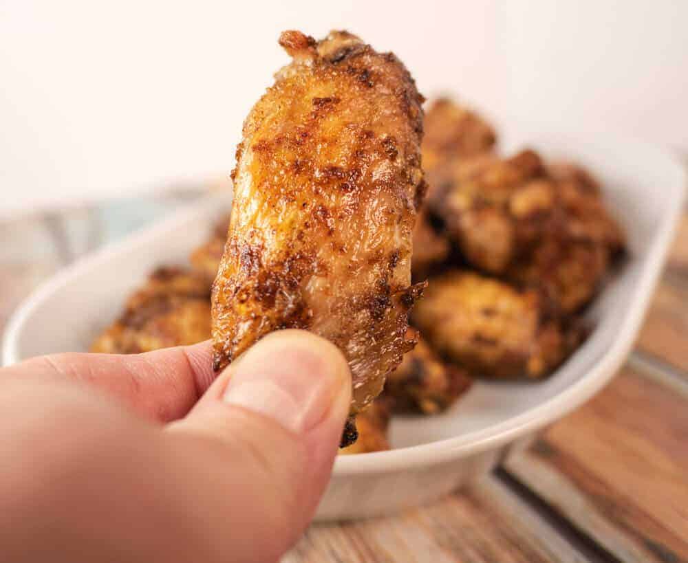 Close up of jerk wing in hand. Golden brown asnd delicious