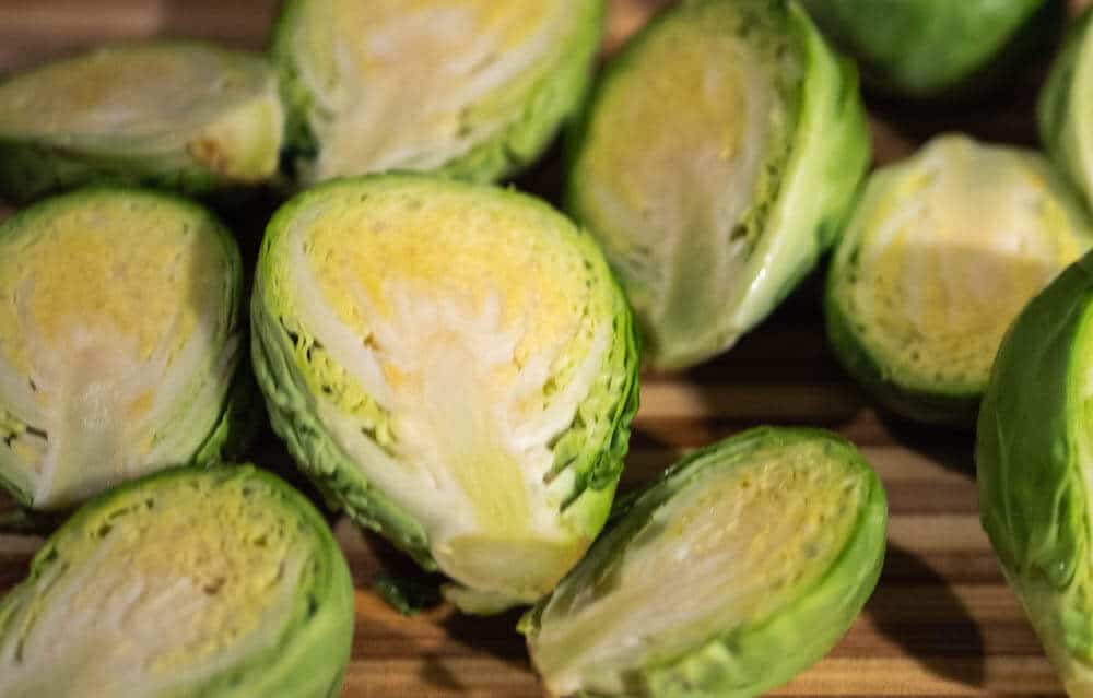 Brussels sprouts prepared and cut in half ready to be roasted.