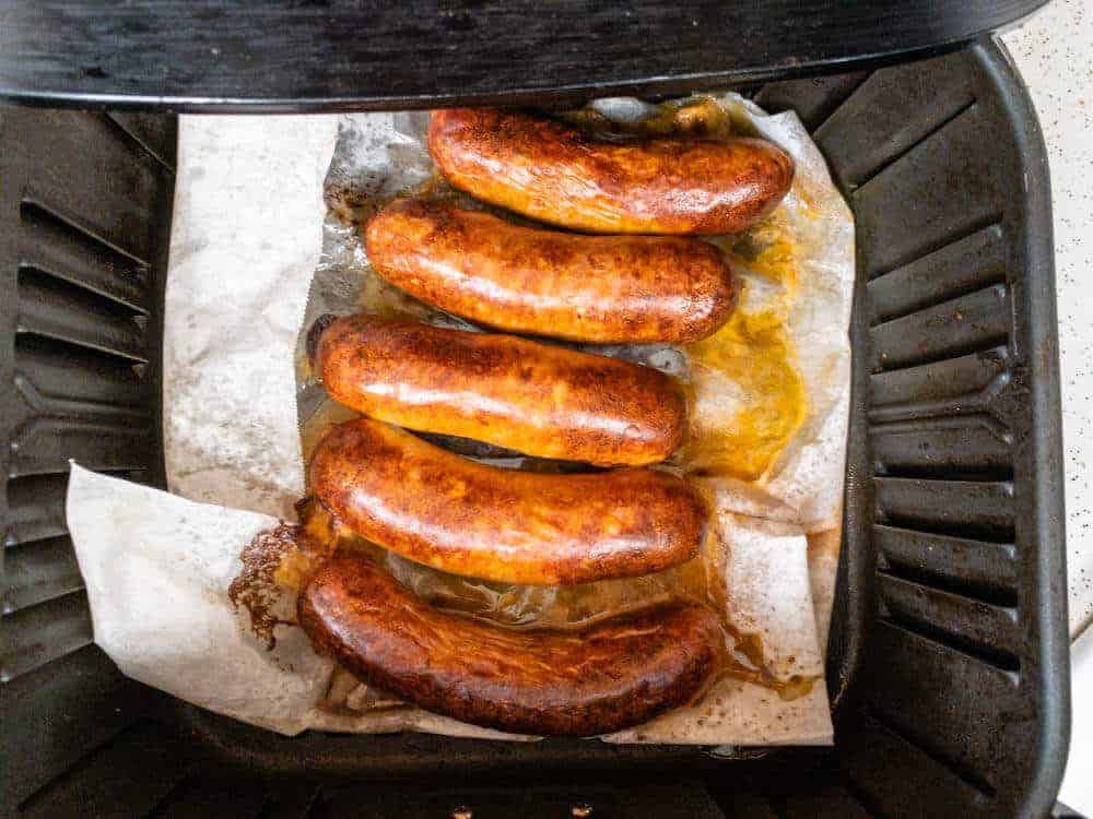 Italian sausage in the air fryer partially cooked and ready to be flipped