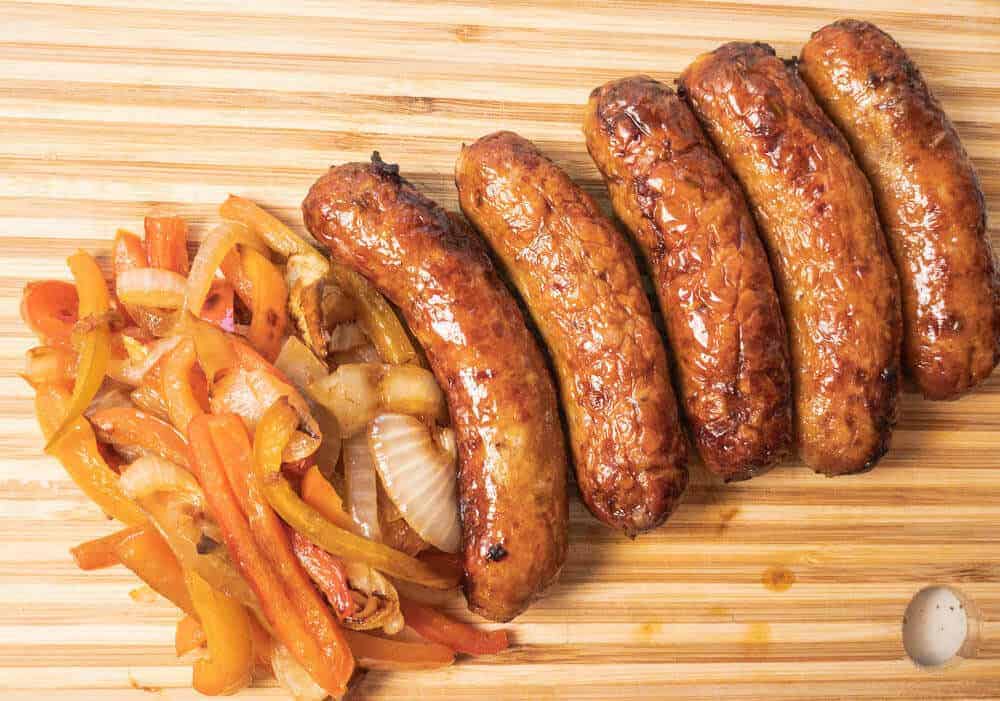 Italian sausage with peppers and onions on serving board above view