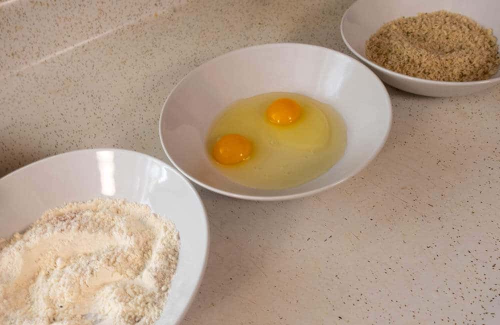 Dredge station of flour egg and breadcrumbs to bread the shrimp.