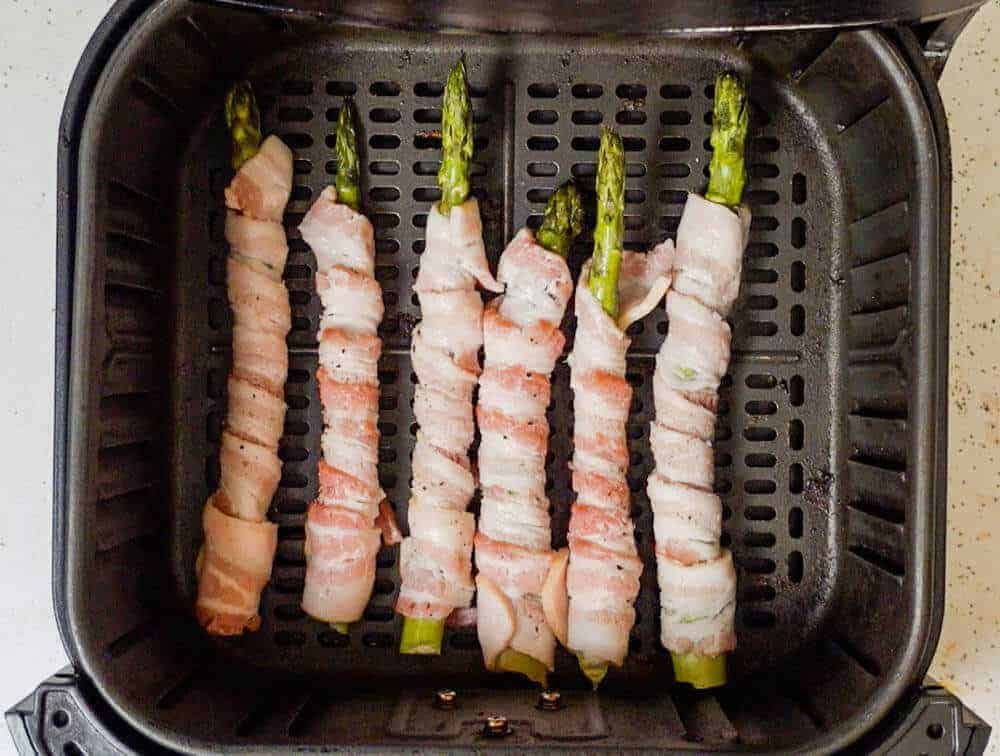 Asparagus wrapped in bacon in air fryer basket