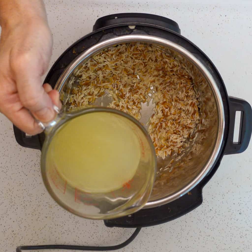 rice pilaf instant pot above view adding chicken broth