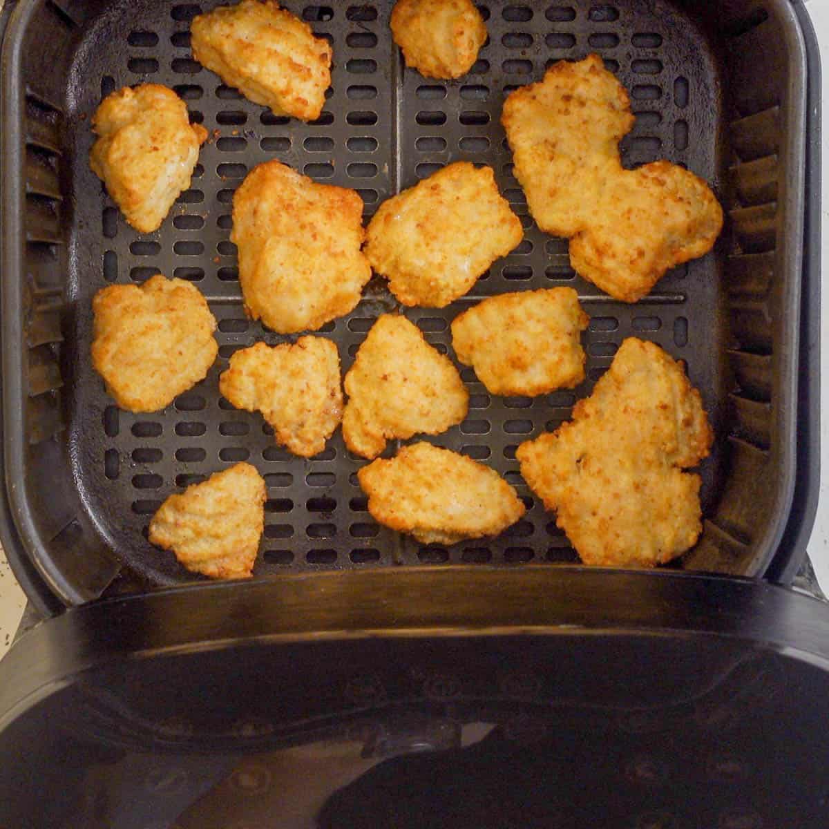 Flipped chicken nugget in the air fryer basket ready to eat