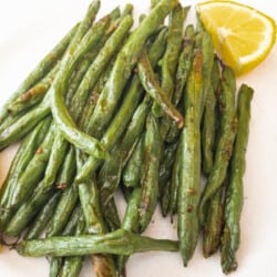 Green Beans on white plate with lemon wedge