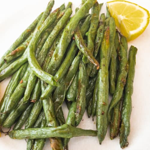 Green Beans on white plate with lemon wedge