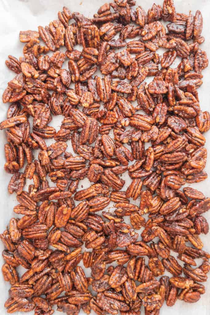 Candied pecans cooling on parchment lined tray