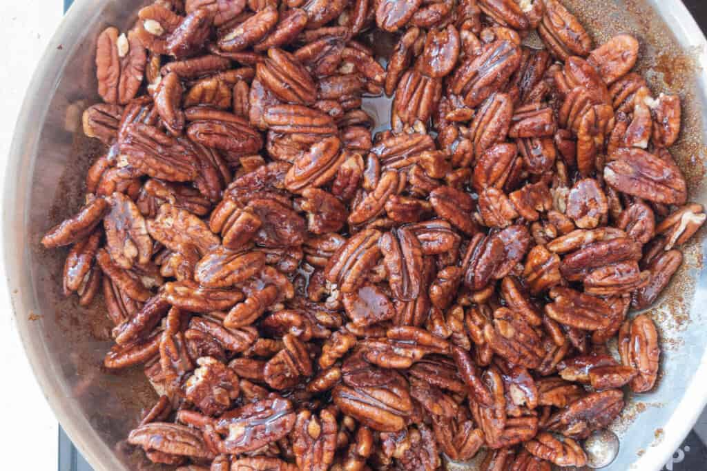 cooking homemade candied pecans in a skillet.