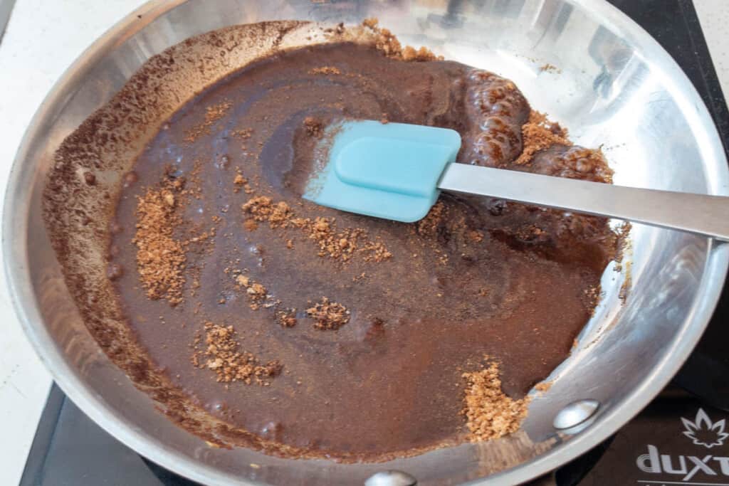 Melting sugar and spices in skillet for candied pecans