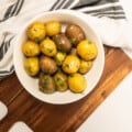 garlic herb potatoes in bowl on serving board