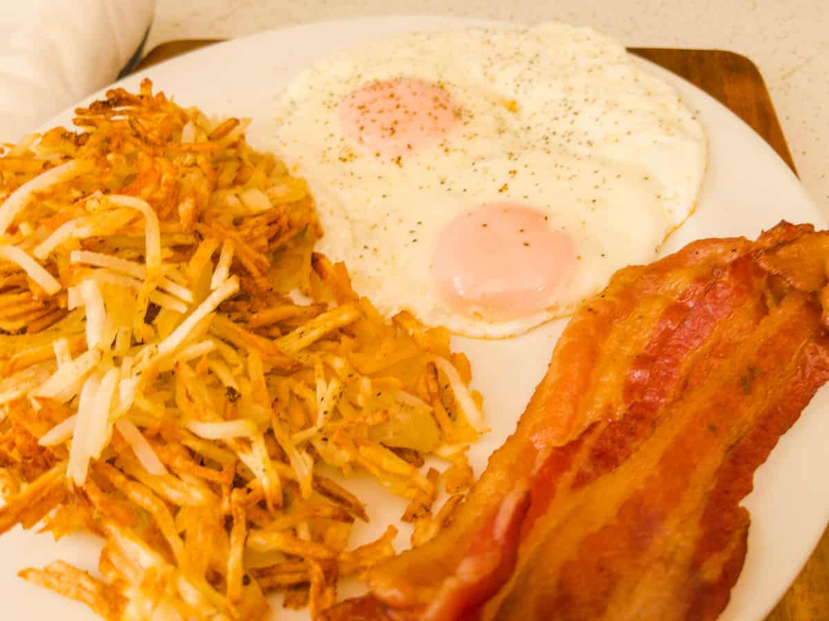 Hash browns eggs and bacon on a plate for breakfast