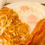 Close up of bacon eggs and hash browns on a plate