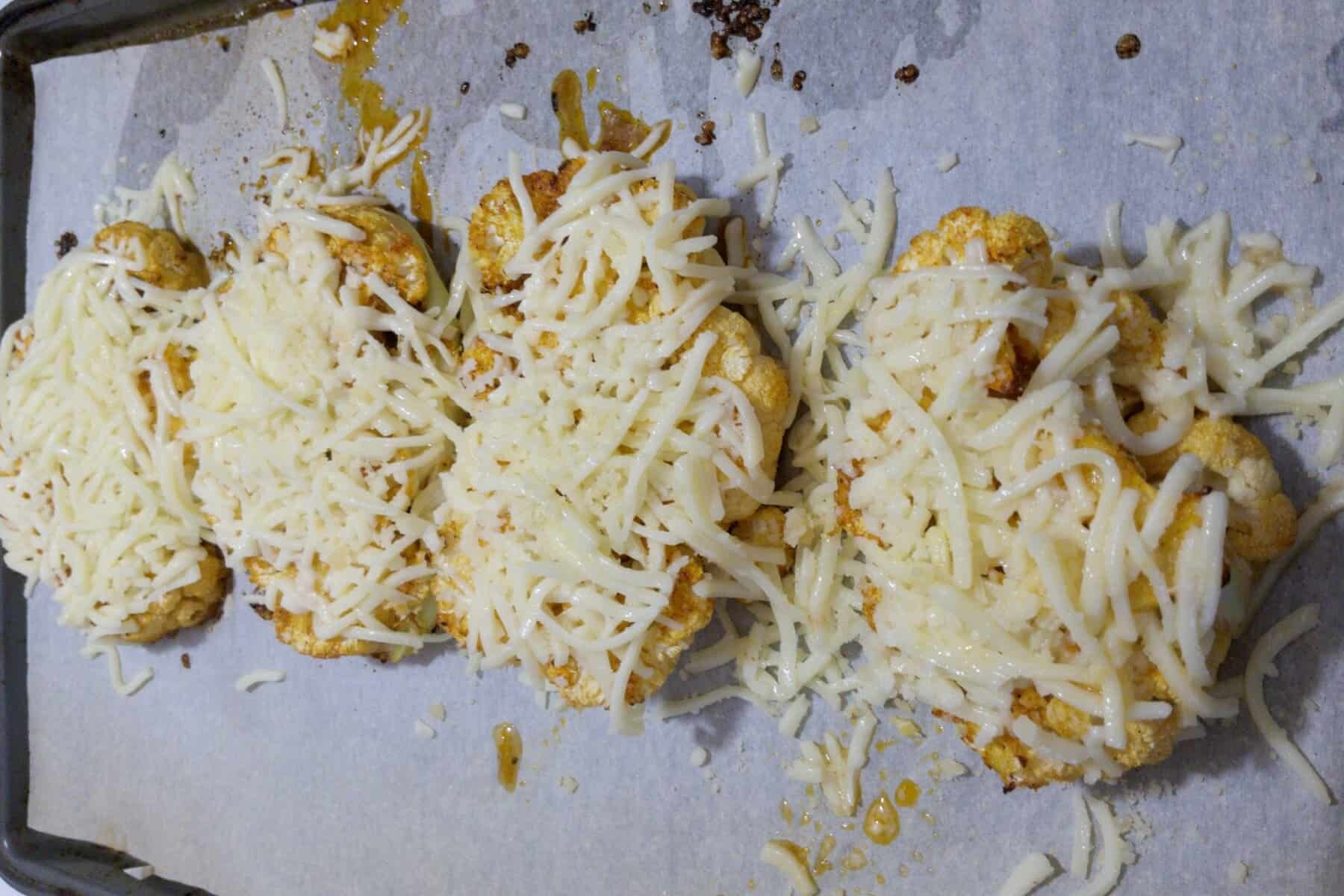 Cauliflower steaks covered in cheese to be melted