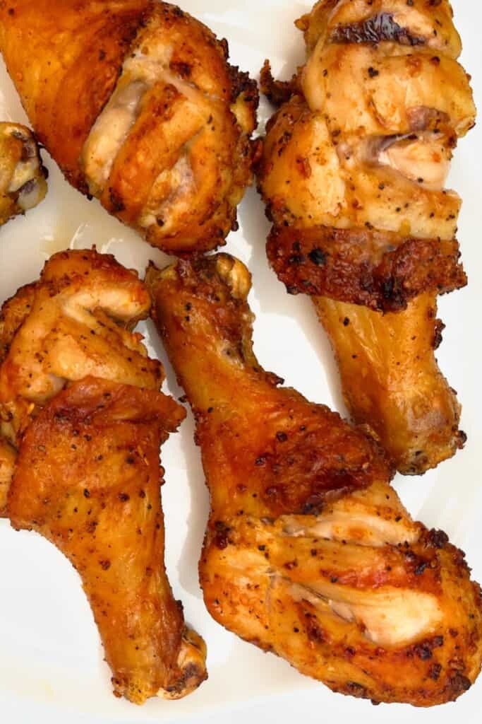 closeup air fryer black pepper chicken legs on plate finished