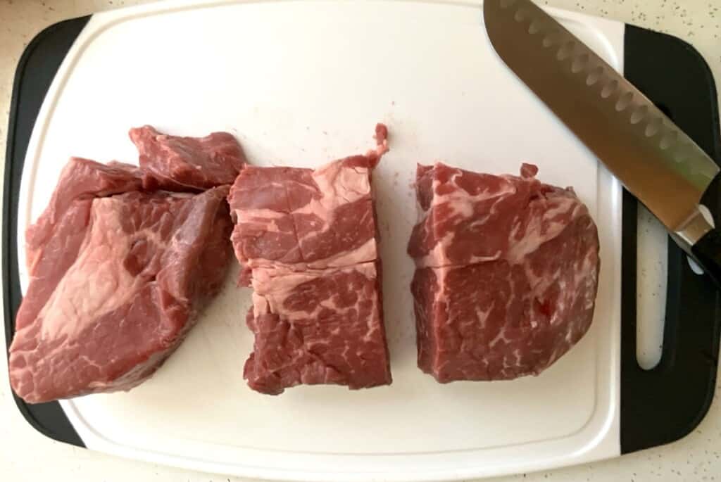 Preparing Chuck Roast Step 1. Cutting into large separate pieces to make instant pot Mississippi roast.