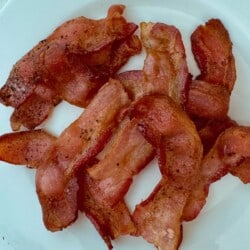 A plate of crispy, perfectly cooked air fryer bacon, highlighting its texture and seasoning.