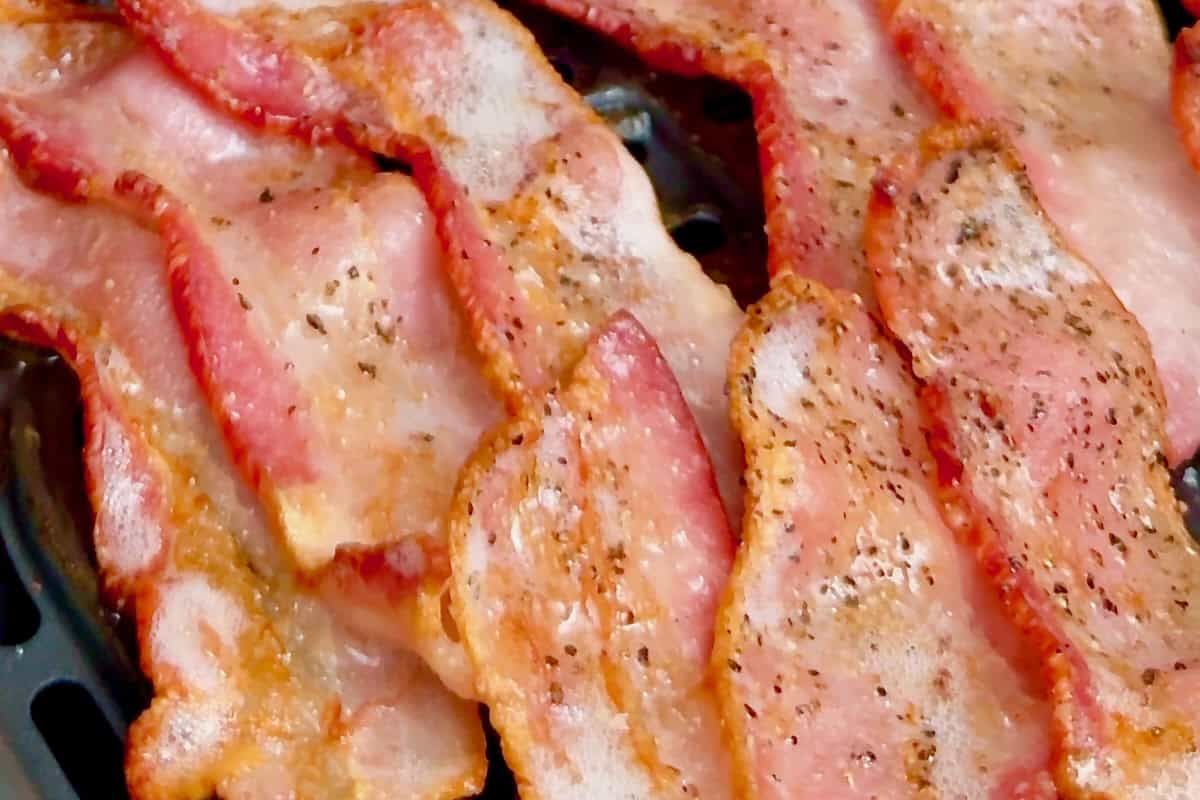 Bacon flipped in the air fryer basket, finishing its final crisping stage to perfection.