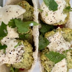 Crispy air fryer falafel served with pita, garlic sauce, and fresh herbs.