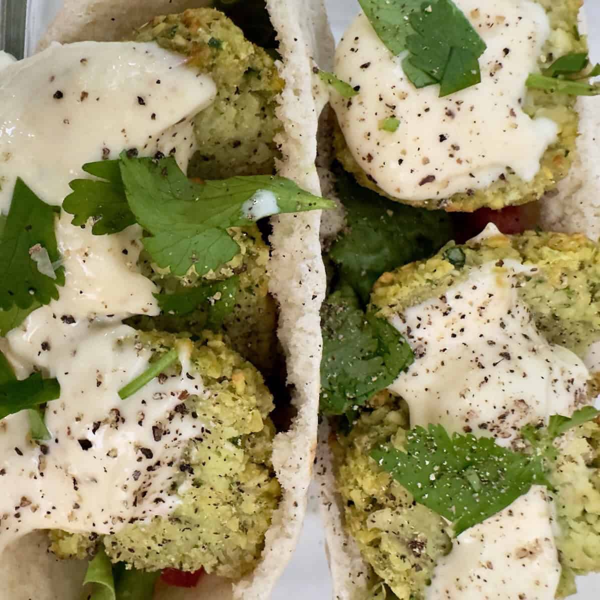 Crispy air fryer falafel served with pita, garlic sauce, and fresh herbs.