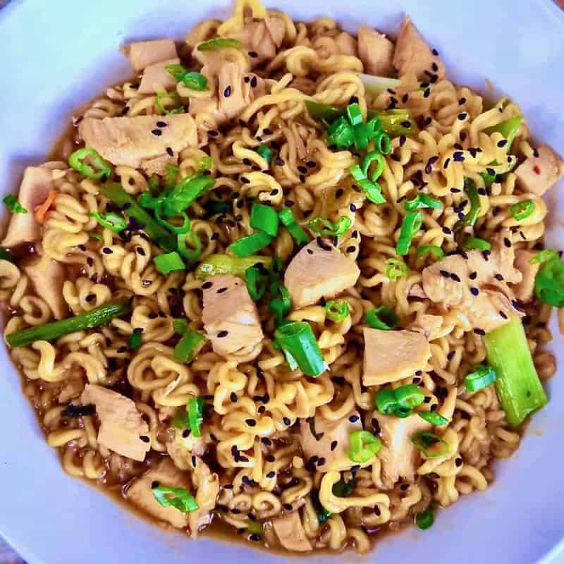 Savory chicken ramen stir-fry with black sesame seeds and scallions.