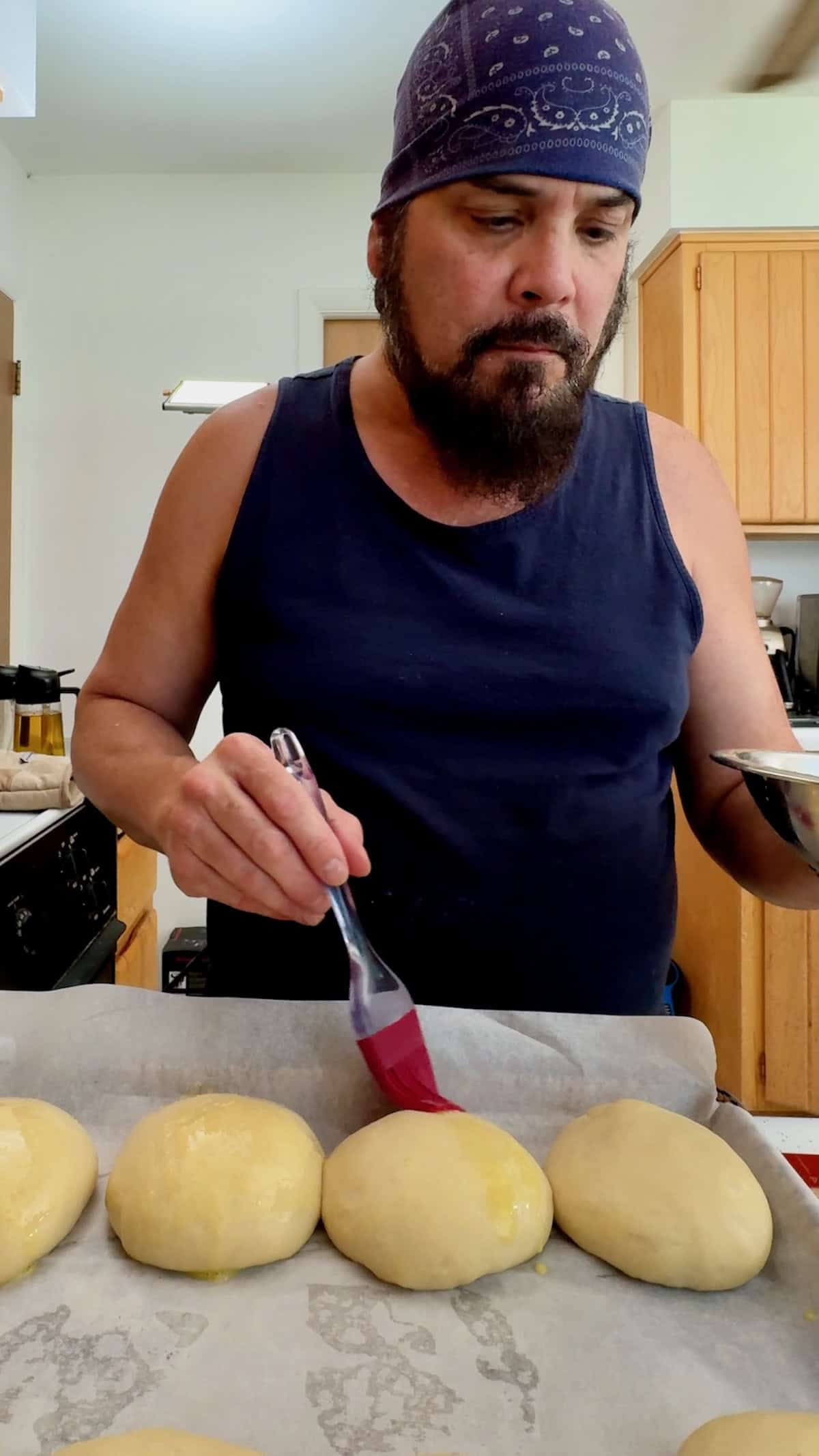 Brushing sandwich rolls with egg wash before baking