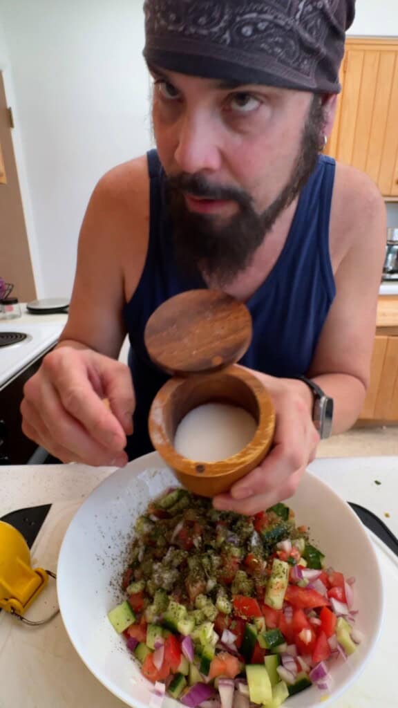Adding salt to season Shirazi salad