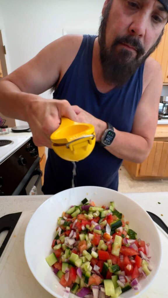 Squeezing fresh lime juice over the vegetables for Shirazi salad