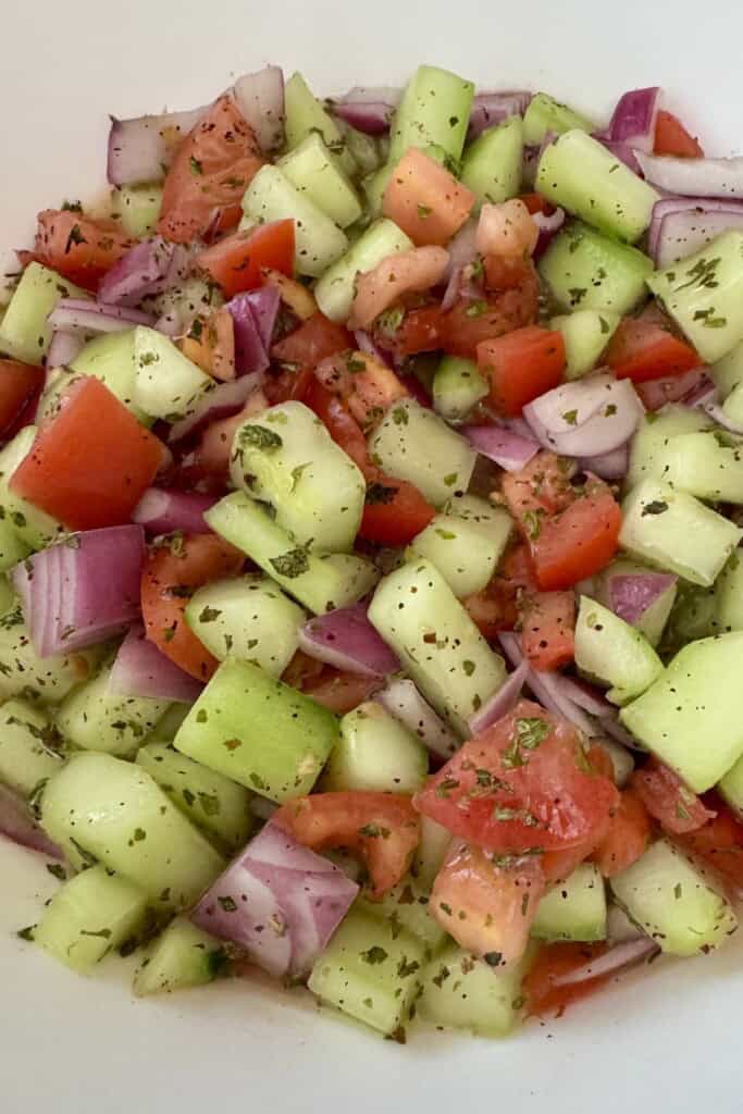 Close-up of homemade Shirazi salad with diced cucumbers, tomatoes, red onion, and dried mint