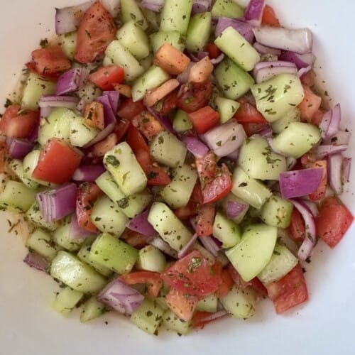 Homemade Shirazi salad made with diced cucumbers, tomatoes, red onion, dried mint, olive oil, and fresh lime juice