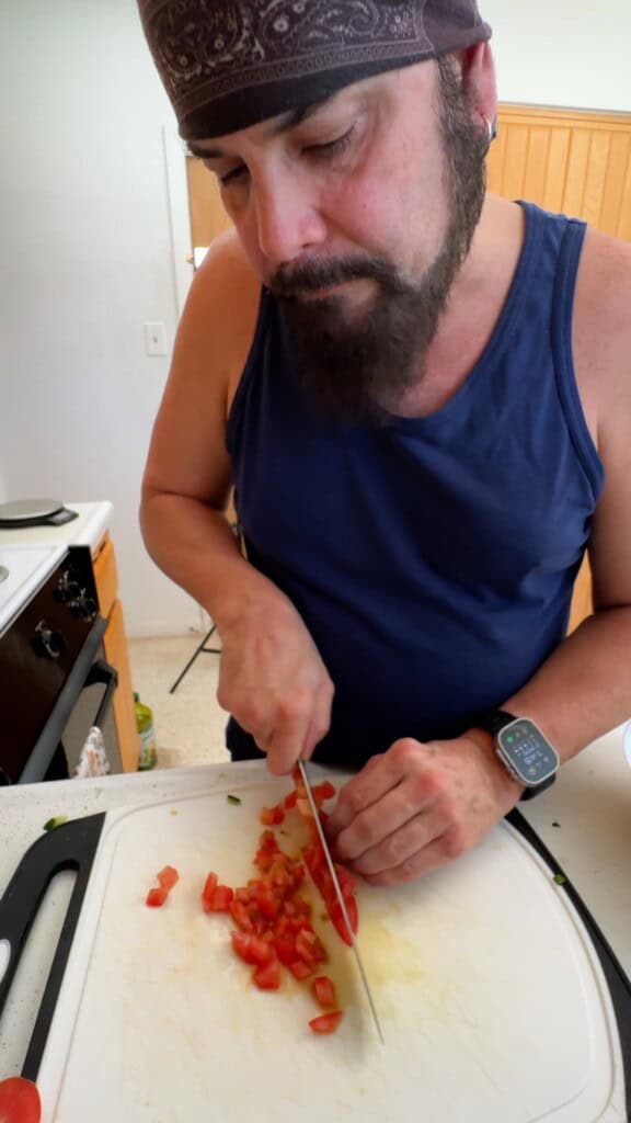 Dicing fresh tomatoes into small pieces for Shirazi salad